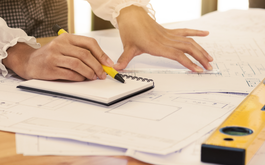 woman with building plans for manufacturing security