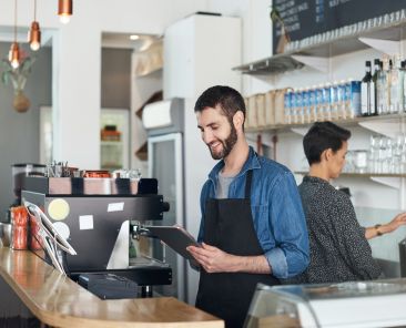 young man using a digital tablet in his coffee shop